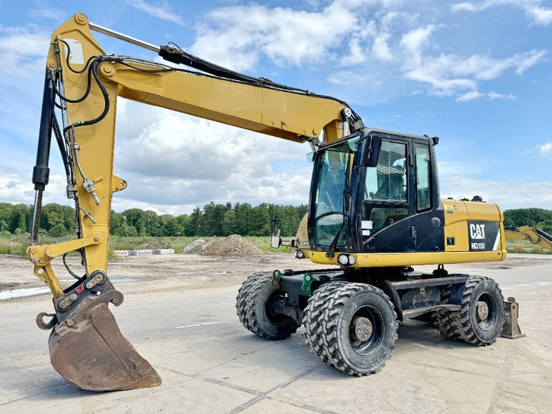 Cat M315D - Triple Boom / Quick Coupler - Bager na kotačima: slika Cat M315D - Triple Boom / Quick Coupler - Bager na kotačima Cat M315D - Triple Boom / Quick Coupler - Bager na kotačima: slika Cat M315D - Triple Boom / Quick Coupler - Bager na kotačima