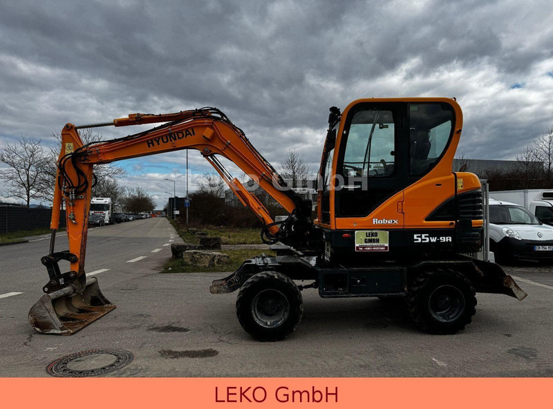 Hyundai Robex 55W-9A Mit Drei Löffeln - Bager na kotačima: slika Hyundai Robex 55W-9A Mit Drei Löffeln - Bager na kotačima Hyundai Robex 55W-9A Mit Drei Löffeln - Bager na kotačima: slika Hyundai Robex 55W-9A Mit Drei Löffeln - Bager na kotačima
